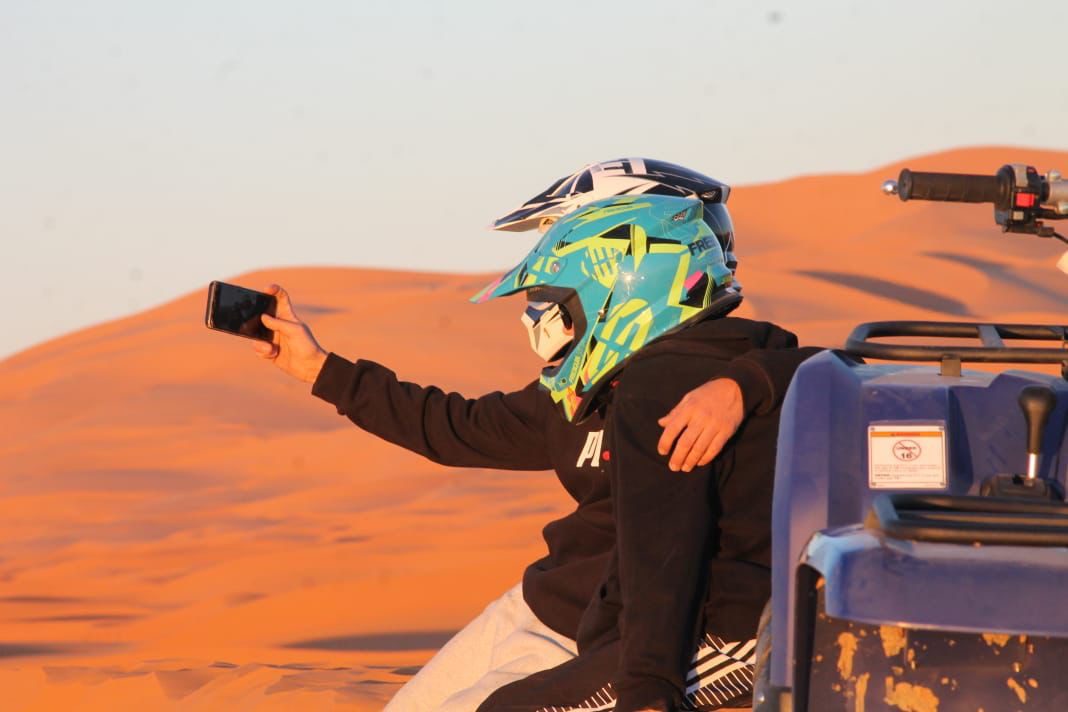 Tourists taking a selfie during a quad biking tour in the Sahara Desert