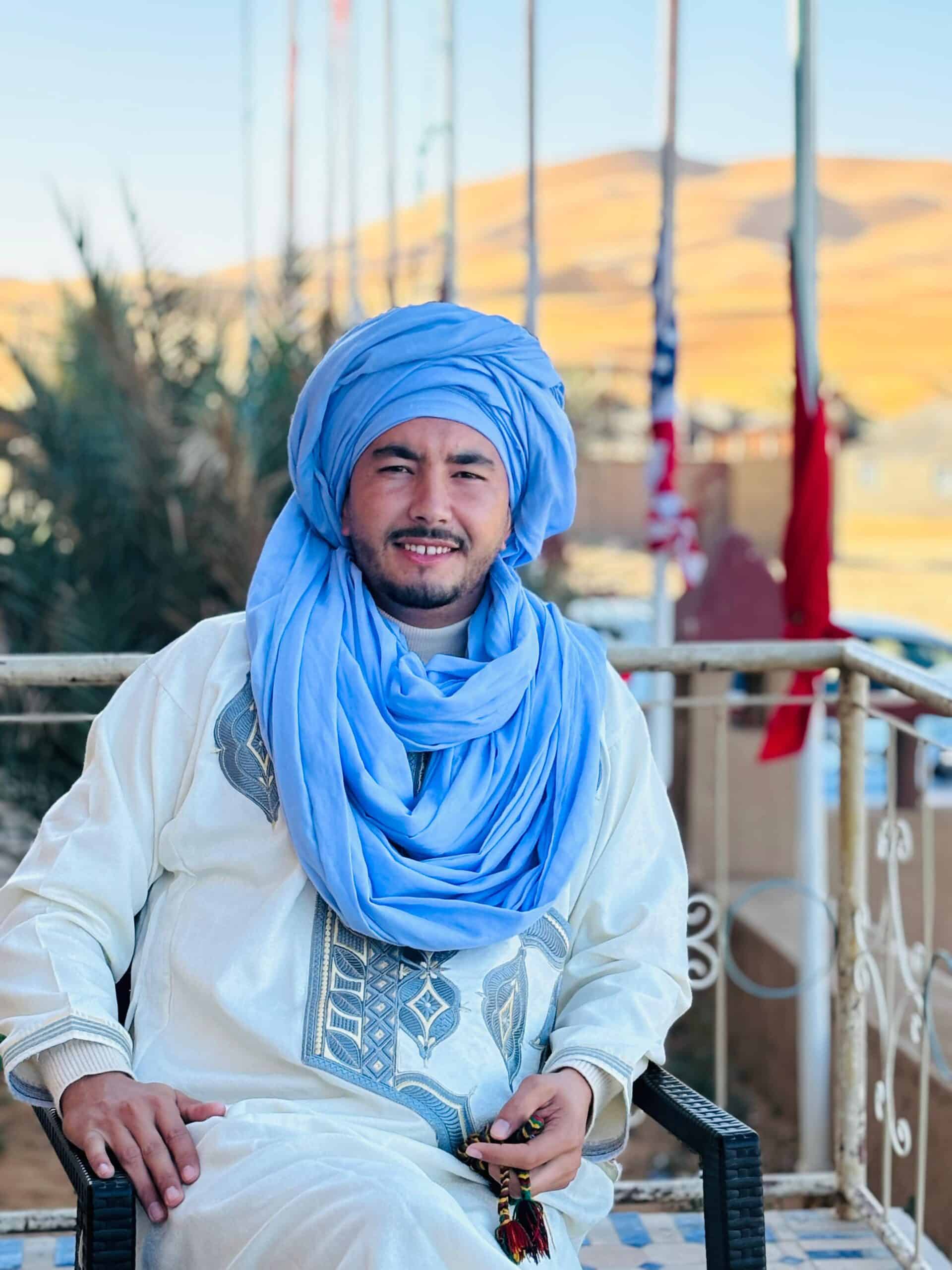 Tour organizer seated with the Sahara Desert in the background