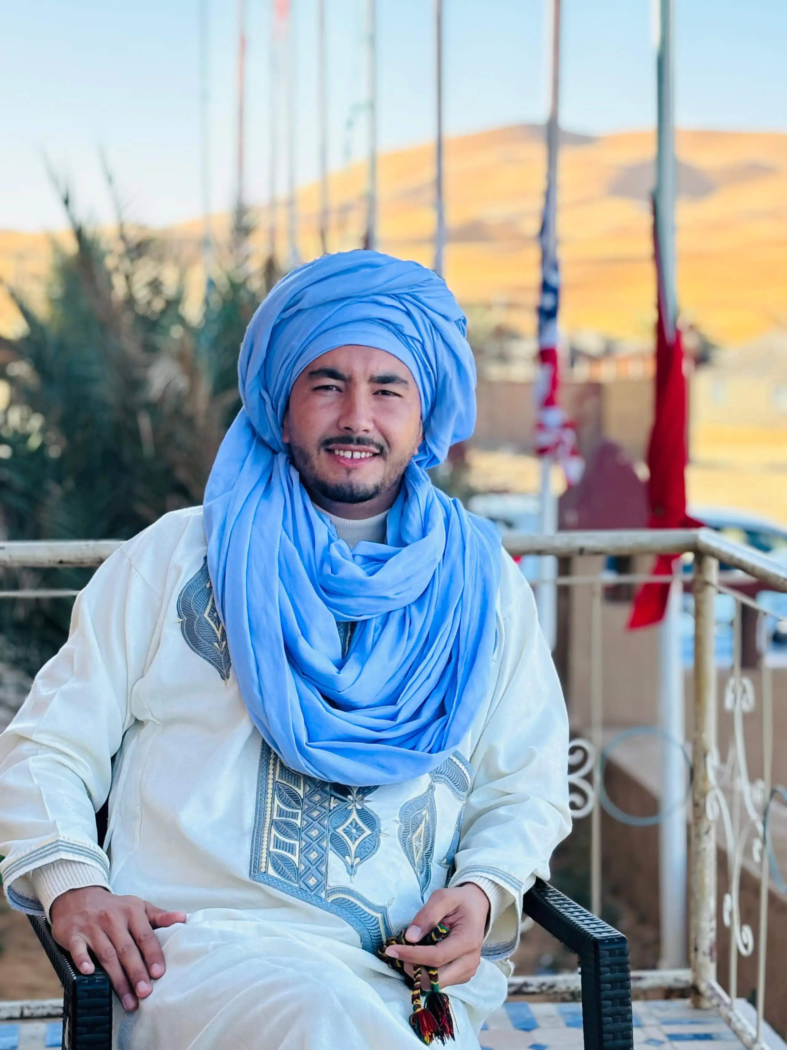 Tour organizer seated with the Sahara Desert in the background